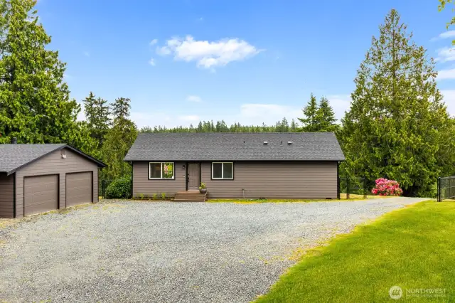 This inviting entry greets you with low-maintenance landscaping and a spacious front area—ideal for greeting guests or simply enjoying your private escape surrounded by towering evergreens.