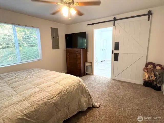 Primary bedroom with barn door to primary bathroom