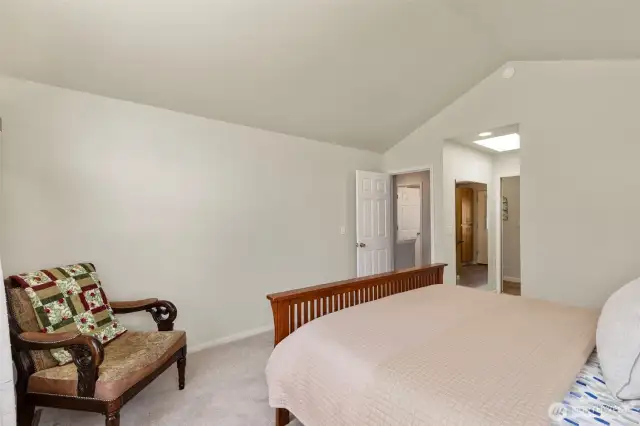 Another shot of the primary bedroom with vaulted ceilings.