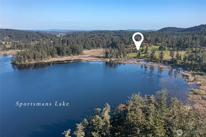 Idyllic setting on 2 acres, tucked alongside Sportsman's Lake and lush forest, offering both privacy and natural beauty.