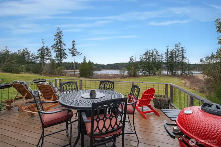 Spacious entertaining deck with sweeping views of the water and surrounding forest, perfect for dining, relaxing, or taking in sunsets.