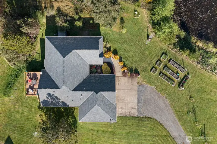Charming single-story home with attached garage, framed by a reflective pond and open green space