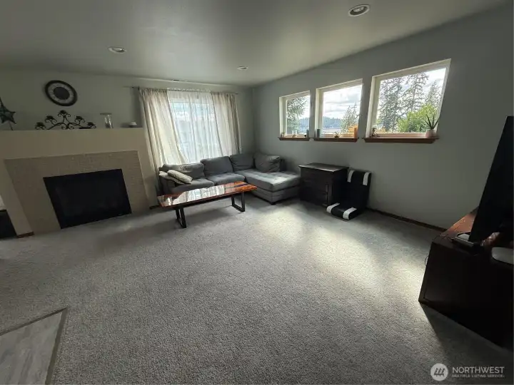 Living room with nice views of Hood Canal and secondary heat via propane fireplace.
