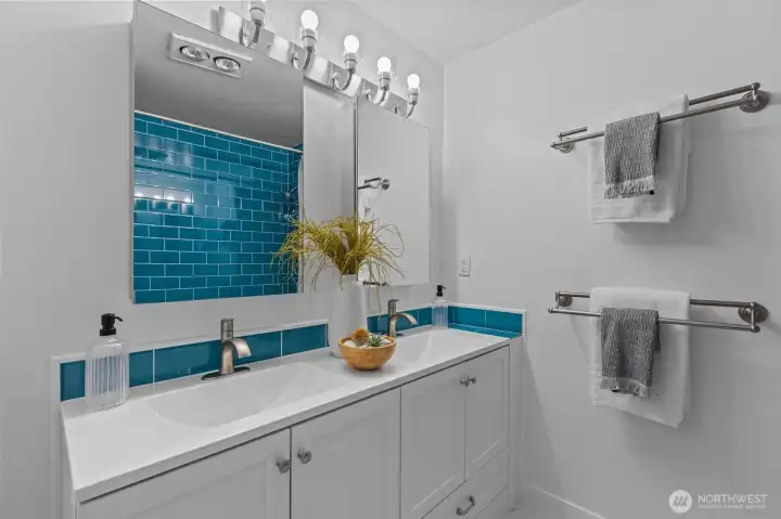 Dual vanity, expansive bathroom with stunning, artful ceramic tile.