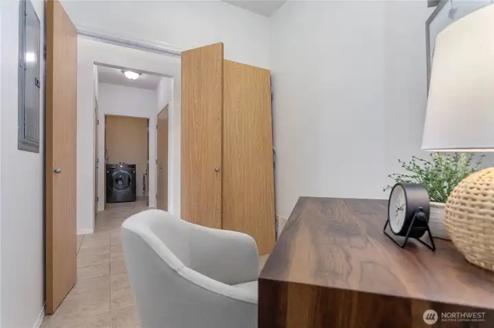 Cozy nook with doors for privacy, located just as you enter the unit. Looking across the hall towards the laundry and more storage closets in the hallway.