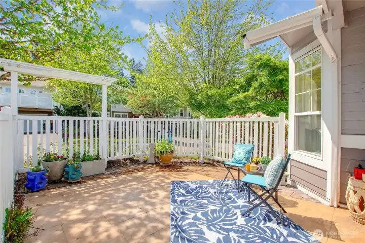 Fenced and gated front patio with garden arbor.