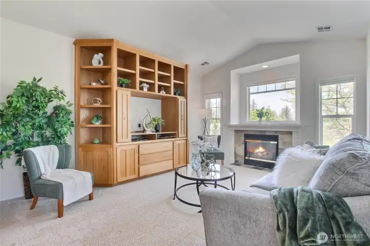 Lovely living room with gas fireplace surrounded by view windows.