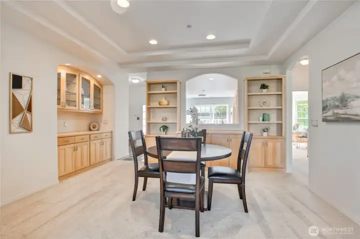 Dining room with built in bar and storage looks through kitchen to front patio.