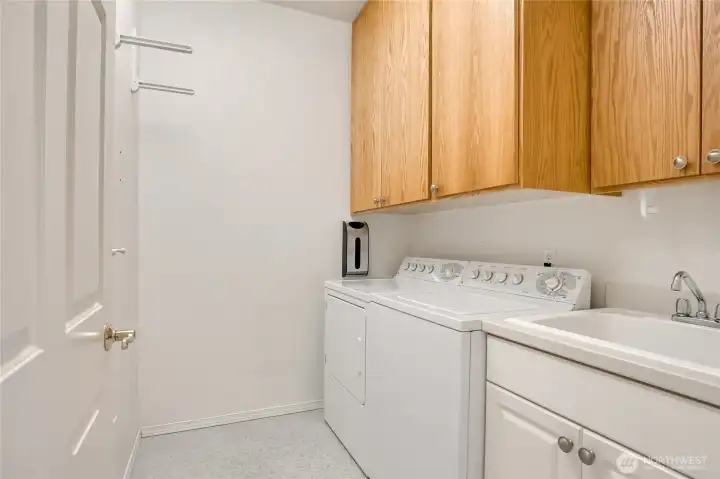 A real laundry room with laundry sink and cabinet space