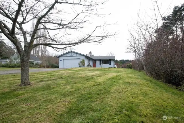 Front yard, view from street. Mature trees around property.