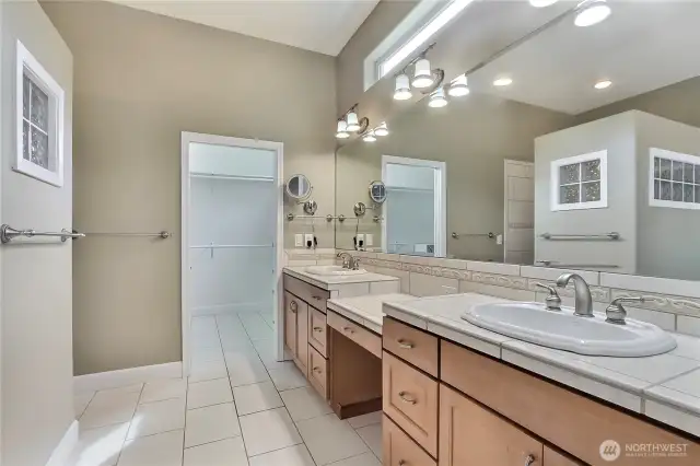 Primary ensuite bath view two, look at all that counter space, huge mirror, large walk-in closet straight ahead. Shaving/makeup mirror a plus!