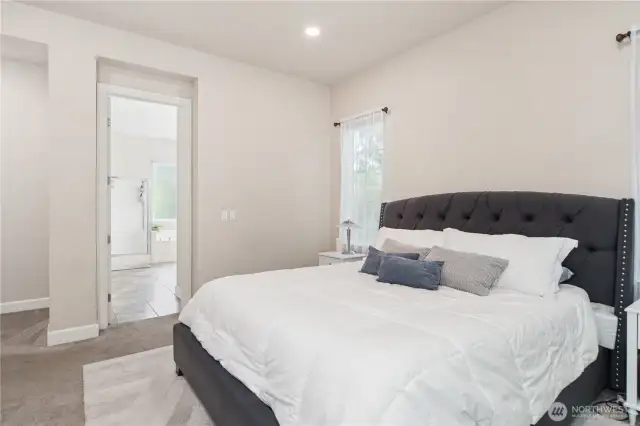 The primary ensuite full bath in beyond the open door. This room easily suits the king-size bedroom set.