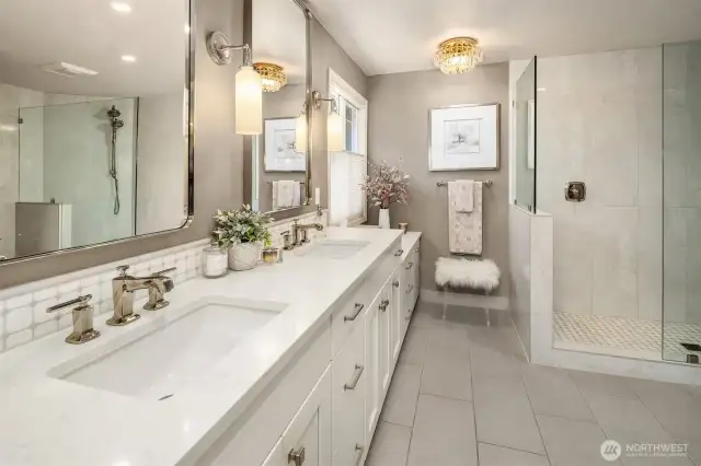 Updated primary bathroom has dual sinks, radiant floor heating and extra storage space.