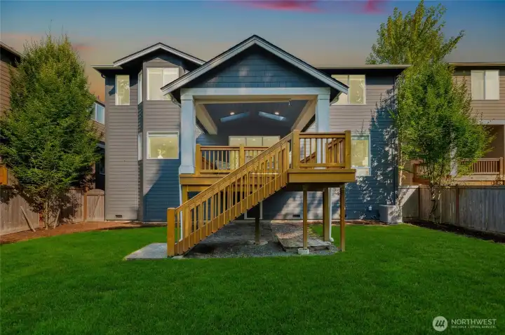 Large backyard with landscape sprinklers. Newly seeded grass.