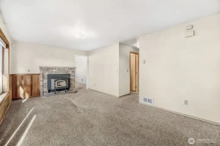 The door next to the pellet stove leads to the den/office and bonus room/home theater. The hallway to the right leads to the second bathroom and the other two bedrooms.