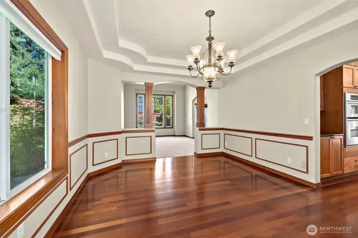 Formal dining room with chandelier, wainscotting, and hardwoods.