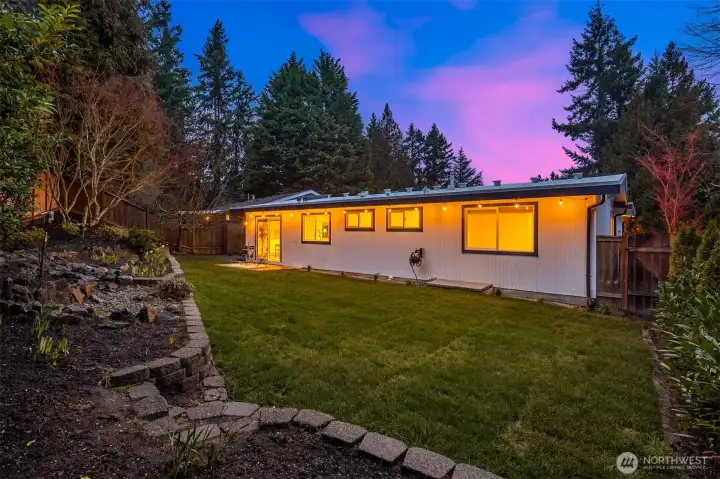 Updated backyard: Pressure cleaning on the retaining wall, new sod, new plantings, new fence.