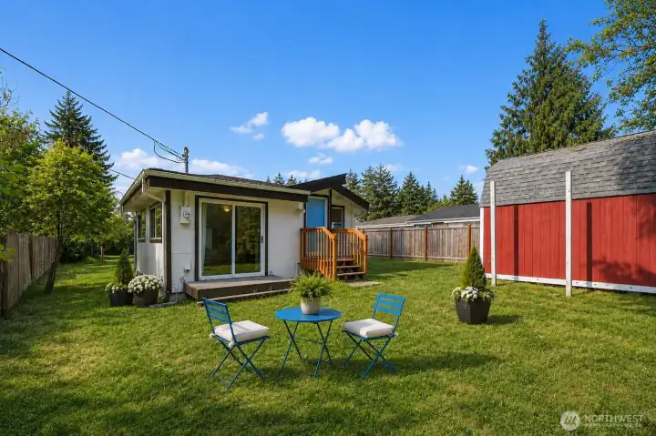 Step into a backyard that feels like your own private retreat — spacious, green, and wrapped in mature trees for a peaceful sense of privacy. The open lawn offers endless possibilities, from summer gatherings and evening firepit seating to gardening, play space, pets, or simply relaxing under the sky. A small deck off the sliding glass door creates an effortless indoor-outdoor connection. The large red storage shed with double-door access and two lofted storage areas adds both charm and impressive functionality, offering abundant space for tools, equipment, seasonal items, and more. A backyard with room to breathe, room to gather, and room to dream.