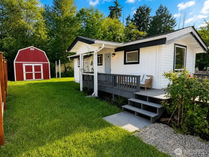 Step into this inviting backyard oasis, where a spacious wrap-around deck with fresh gray railing offers the perfect spot for morning coffee or evening relaxation. Complete with comfortable seating and surrounded by lush, vibrant landscaping, this outdoor space feels like an extension of the home.