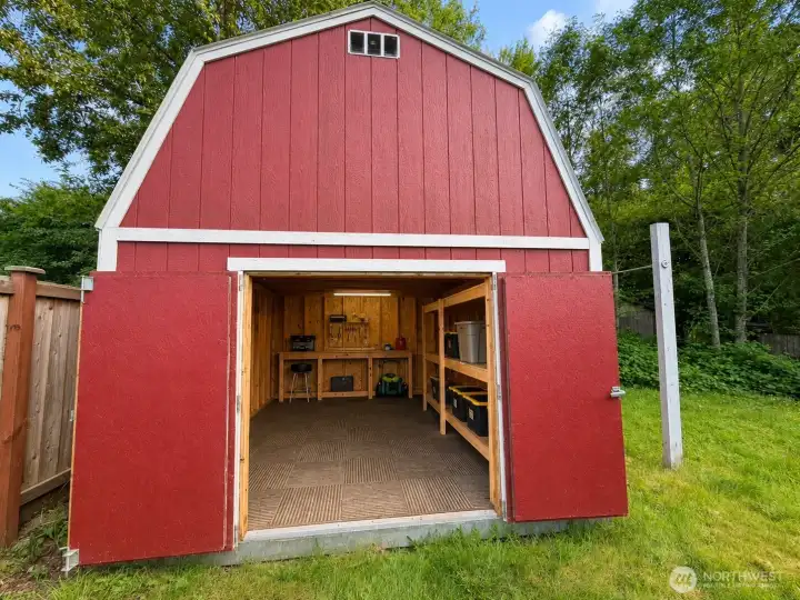 Roomy, well-lit workshop/storage shed with workbench, extensive shelving, and high ceilings — perfect for projects or extra storage. Whether you need a dedicated workshop, garden center, home gym, or extra garage space, this well-built structure delivers functionality and room to grow. Located right on the property for convenient access.