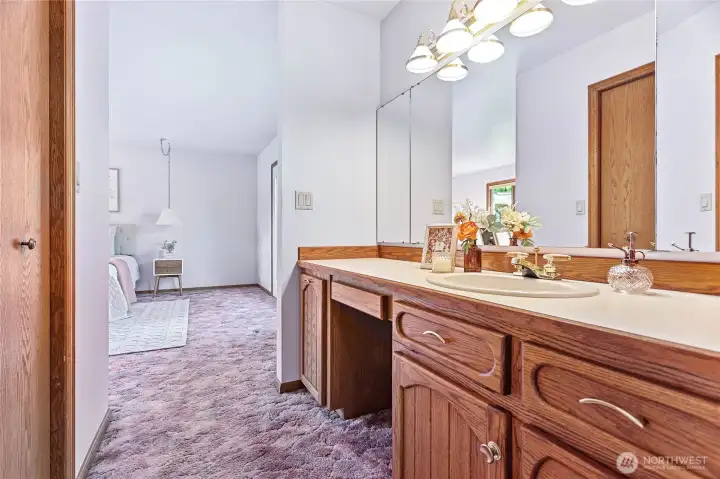 Ensuite vanity w/built in hamper cabinet. Walk-in closet through door to left. Pocket door behind pic leads to rest of full bathroom