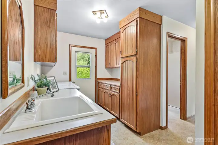 Behind family room you'll find huge utility room w/another access door to backyard. Garage door to right just behind pic. 3/4 bath through open door. Hall leads to basement access