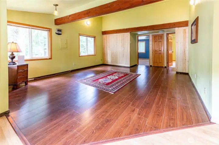 Living room looking toward the two bedrooms. Open, flexible layout with hardwood-look flooring throughout the main level.