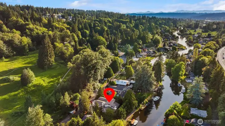 A NW contemporary home situated on an 16,717 sq ft lot with 90' feet of low bank riverfront with access to Lake Washington. This 3 bed+loft /2 bath home is move-in ready just in time for summertime!Easy access to Lake Washington and across the street from the home is Bythe Park (former Wayne Golf Course). Also walk to the Burke Gilman trail and bike all the way to Seattle!
