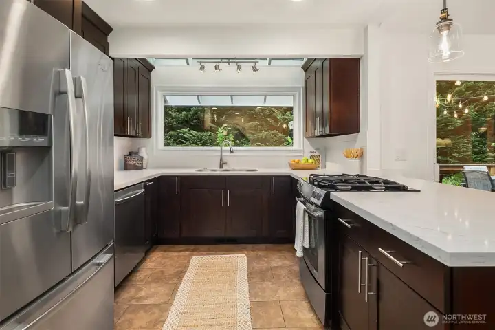 Refreshed kitchen with quartz countertops, backsplash and stainless steel appliances. Picture window looks out to a private view of the river.