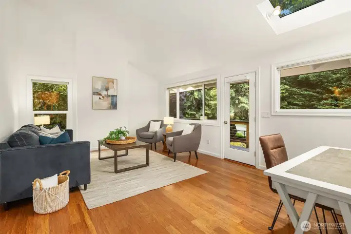 Another great room with vaulted ceilings, skylights, and wood flooring with French door leading out to the Trex deck and backyard that leads to the dock on the river.