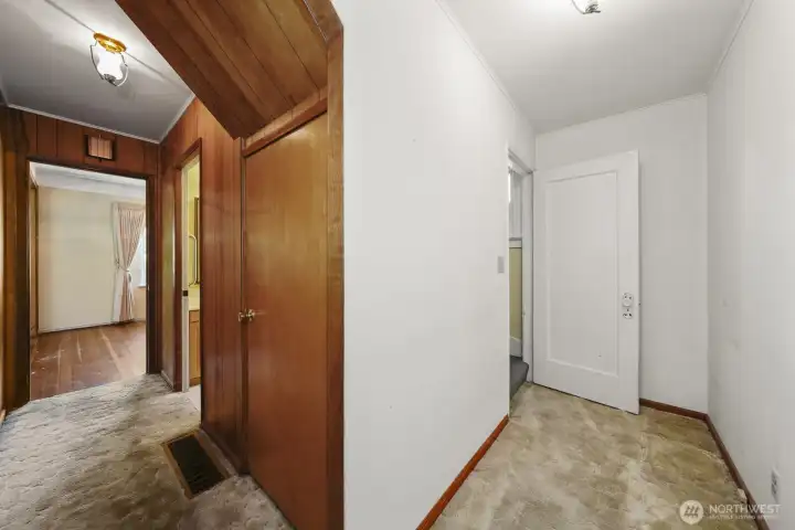 Main level hallway, door to the right leads to upstairs Main level hallway, door to the right leads to upstairs