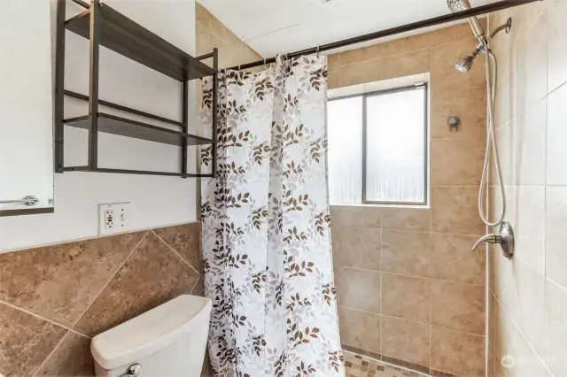 Bathroom in the first lower-level separate living unit with a spacious walk-in shower.