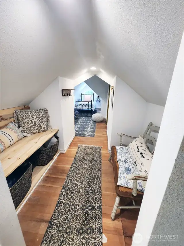 To the left of the stairway is a storage and seating area.