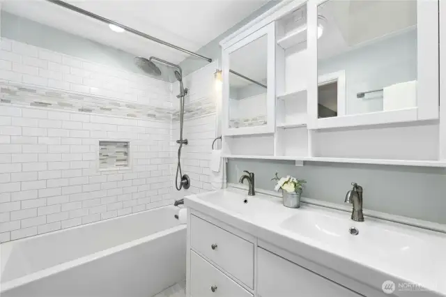 The remodeled primary bath features double sinks, medicine cabinet storage, and a skylight.
