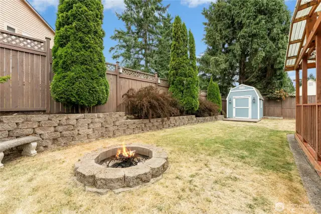 Private, stylishly updated retaining walls, firepit, and a shed--this backyard really does have it all!