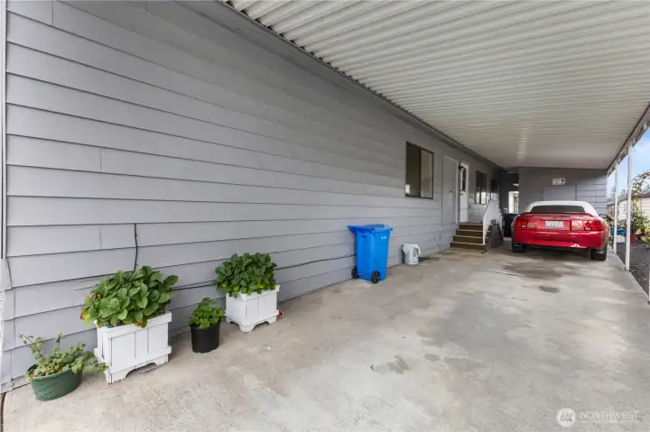 There is a deep carport with the entrance to the home / utility room up the stairs to the left. There is a secure storage shed at the end of the carport