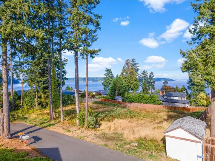 You won't find much level and buildable land in town, but here is a rare lot that has views across to Gig Harbor East side to Vashon and beyond  - you don't even have to tear a house down to build on.
