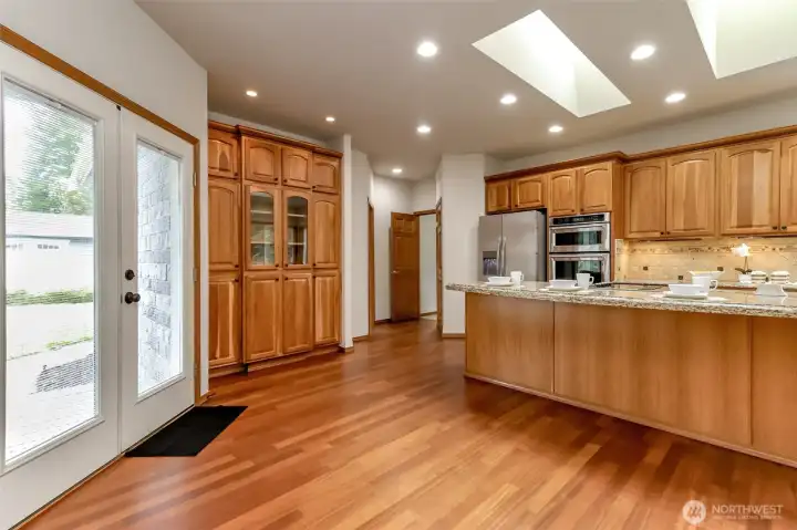 Kitchen hosts custom cabinetry and French Doors to the side porch.