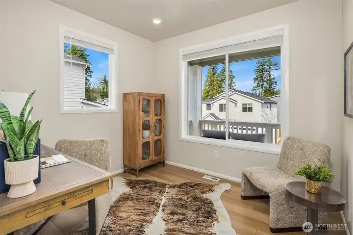 Office on main floor looks out over covered deck and charming street.