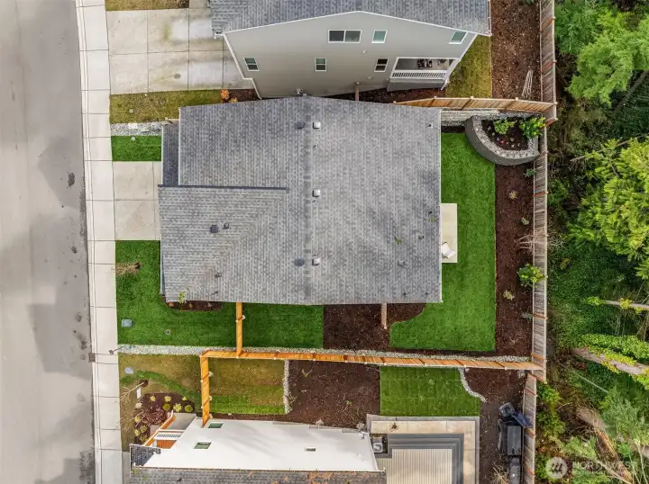 Aerial of lot with a large side yard and mature greens.