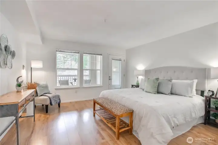 Primary suite with door to spacious balcony, solid surface floors, walk in closet, and ensuite bath.