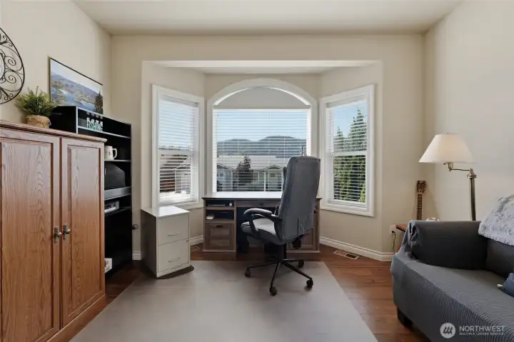 Bright guest room with large windows, attractive flooring, and versatile living options.