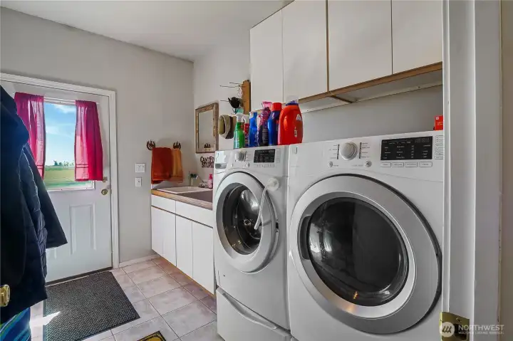 Dedicated laundry room with additional storage space.