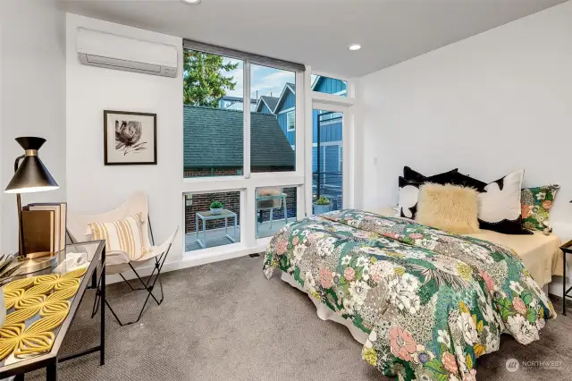 Spacious bedroom on the second level complete with a big closet, floor-to-ceiling windows, and an access door to the sitting deck. The windows slide open to allow for natural air flow.  Yes, there is also an energy-efficient mini-split with air-conditioning to keep you cool all summer long or toasty in the winter!