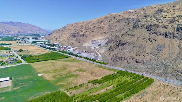 This aerial view from over the ranch house highlights the large example of land for sale but also the close proximity to commercial zoning at the intersection just to the north of the property.  That is US 2/97 highway with Lake Chelan to the north and Wenatchee to the south