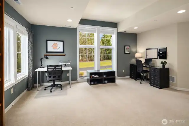 The upstairs Library / loft area has big dual pane windows to take in the lovely yard views, built in book shelves, plush carpet, and designer paint colors.