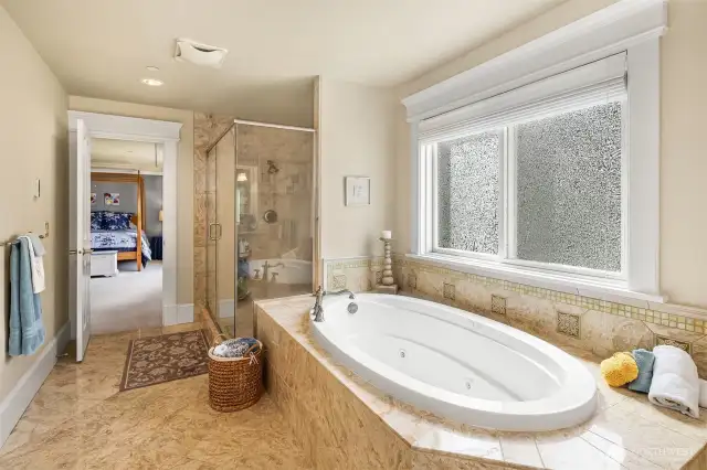 The master bathroom comes with separate jetted bath tub and larger tile shower with seamless glass enclosure