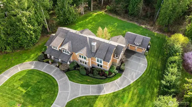This spectacular home sits on nearly 3 acres of mostly level land. A wonderful lot with the forest out back  creating privacy and tranquility in your backyard area.  The drive to the right goes into the fully finished  4 car garage.