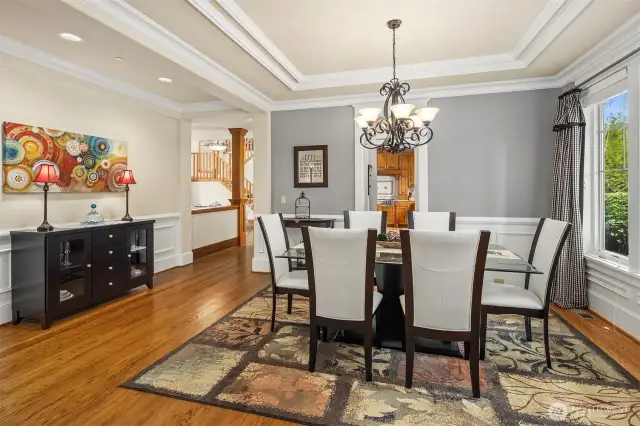 The semi formal dining room with lovely views into the front yard area.  Notice the detail to the crown molding, wainscoting, paint color and drapery.  Big enough for your larger gatherings.