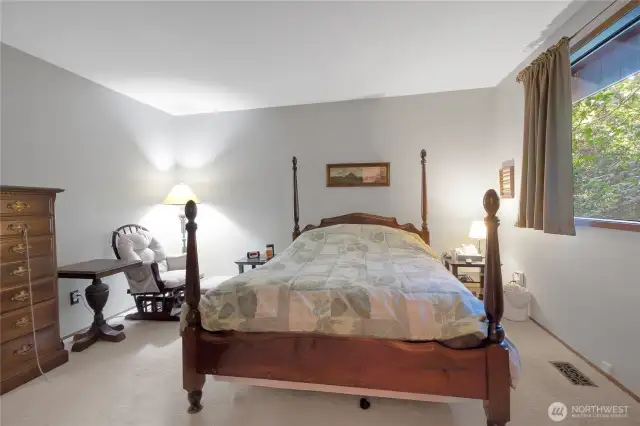 The spacious primary bedroom easily accommodates a king-size bed and offers direct access to the en-suite bathroom.